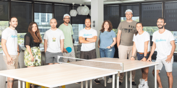 Hardbacon's team of employees around a pingpong table